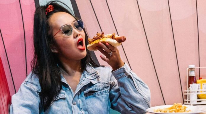 Sausage and Pepper Hoagies With Harissa Mayo A Woman Eating A Hotdog Sandwich